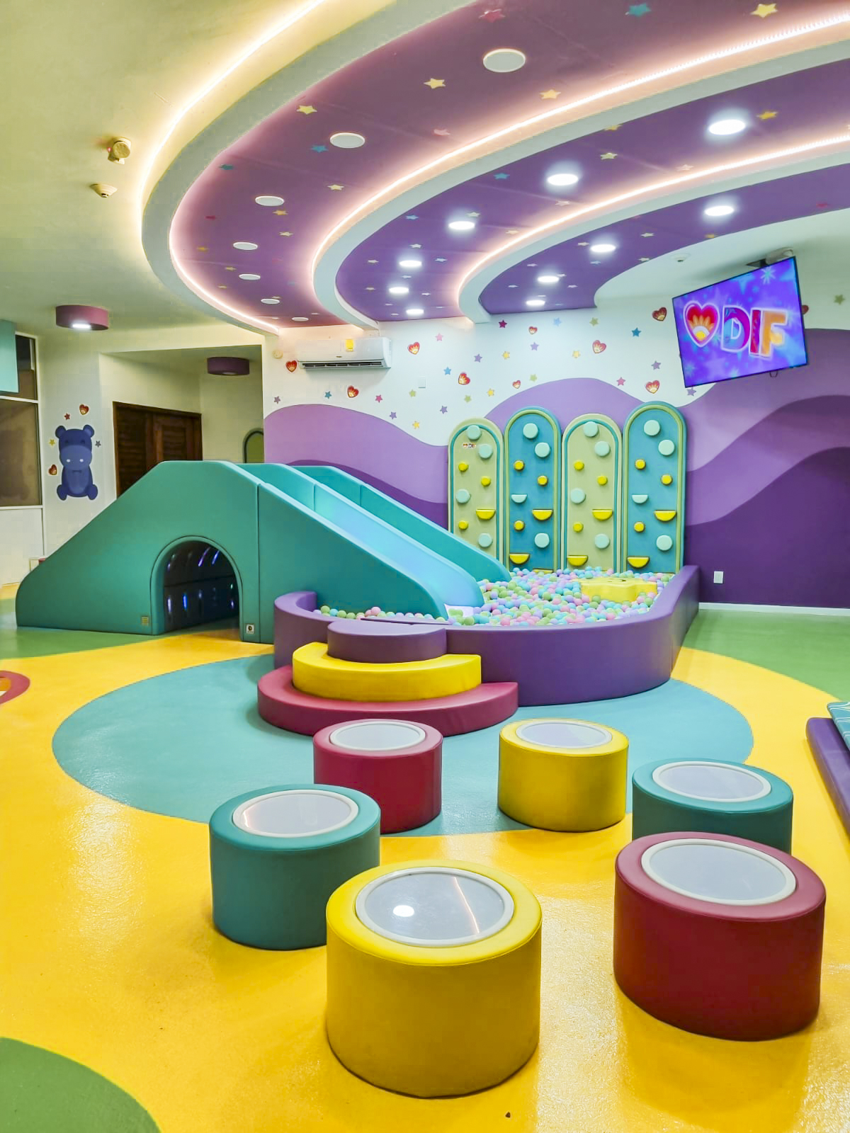 Detalle del espacio infantil con elementos visuales, táctiles y motrices creados por inwow.